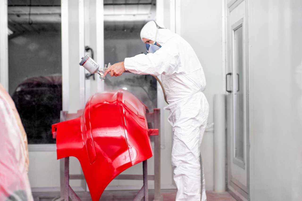 St-Louis-auto-body-worker-spraying-red-paint